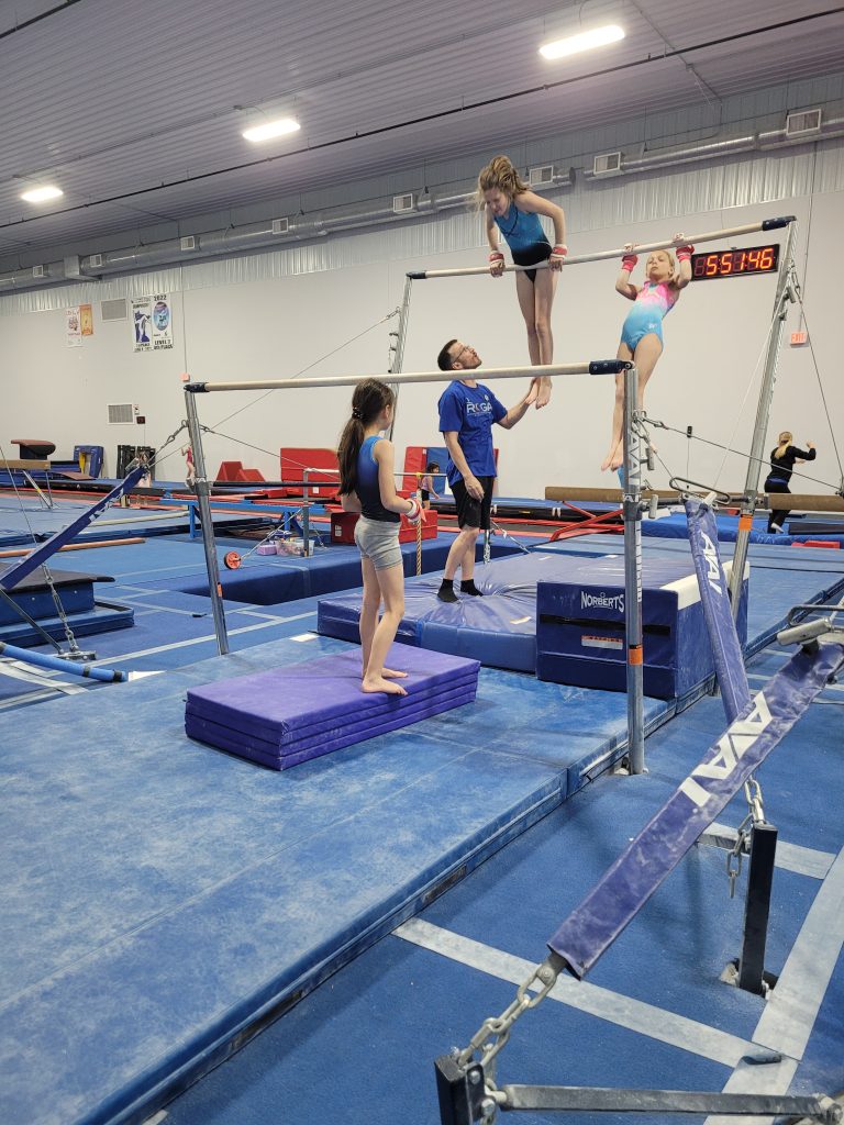 Girls practicing gymnastics with high bar