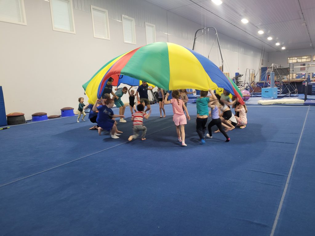 Kids playing with a parachute at Kids Night Out