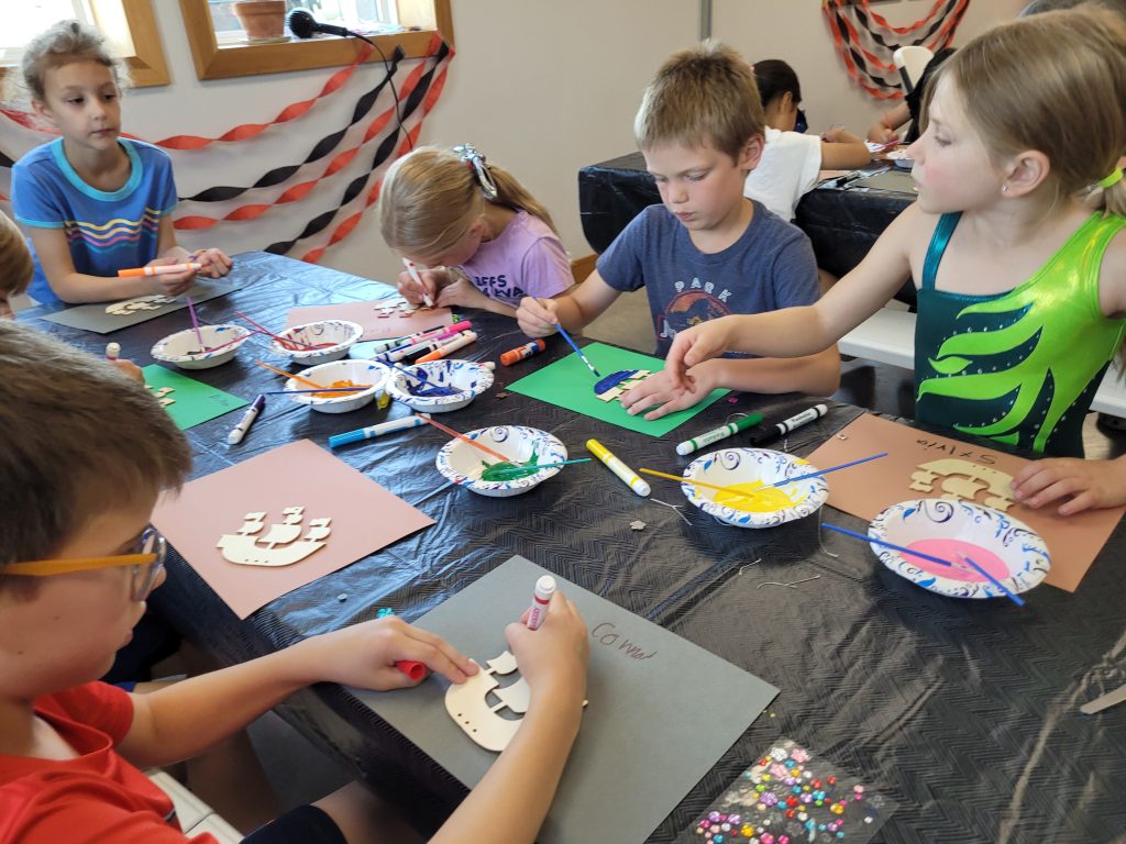 Kids participating in crafts at Camp ROGA