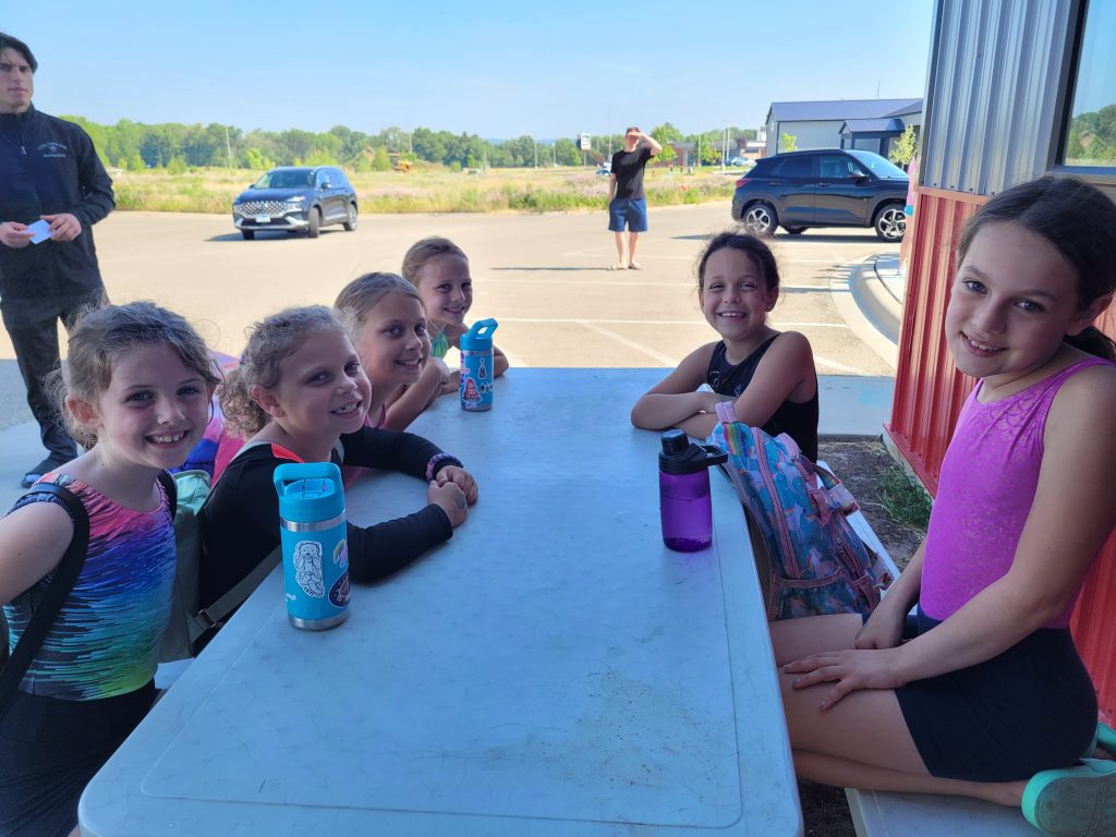 Kids outdoors at a picnic table at Camp ROGA