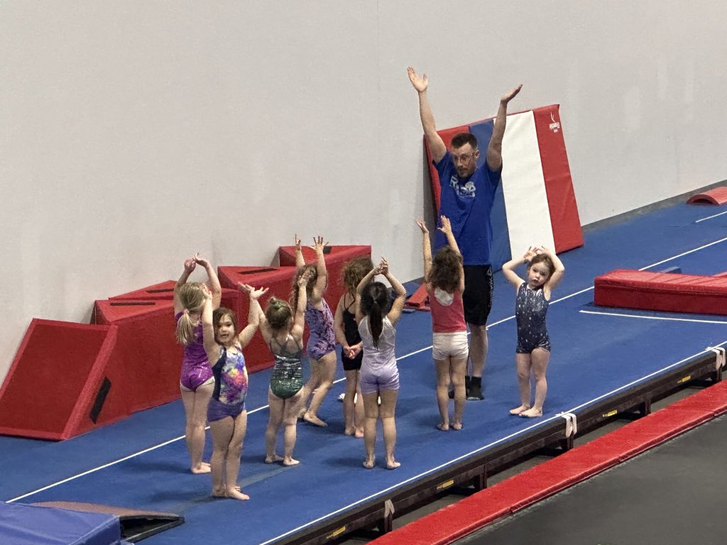 Children learning recreational gymnastics in a large group