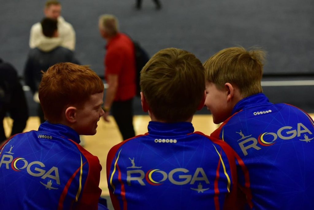Boys in ROGA uniforms talk at a meet