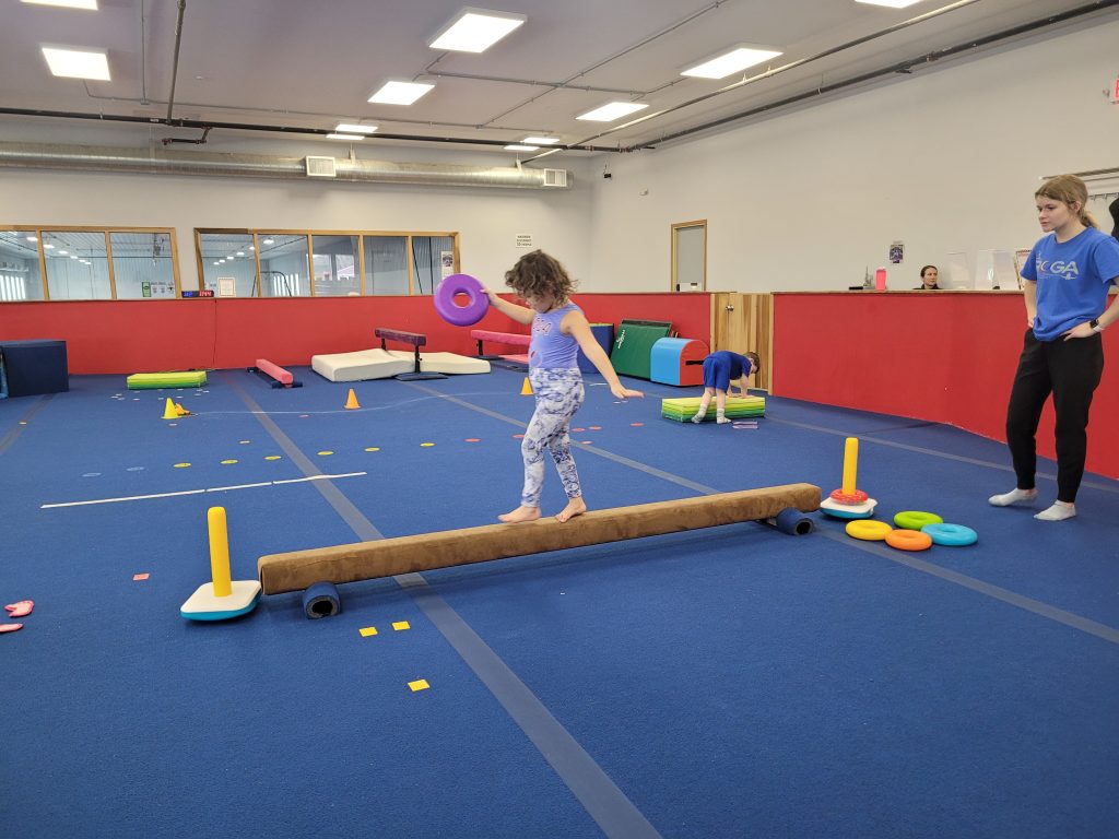 A preschool-aged girl learning to use balance beam