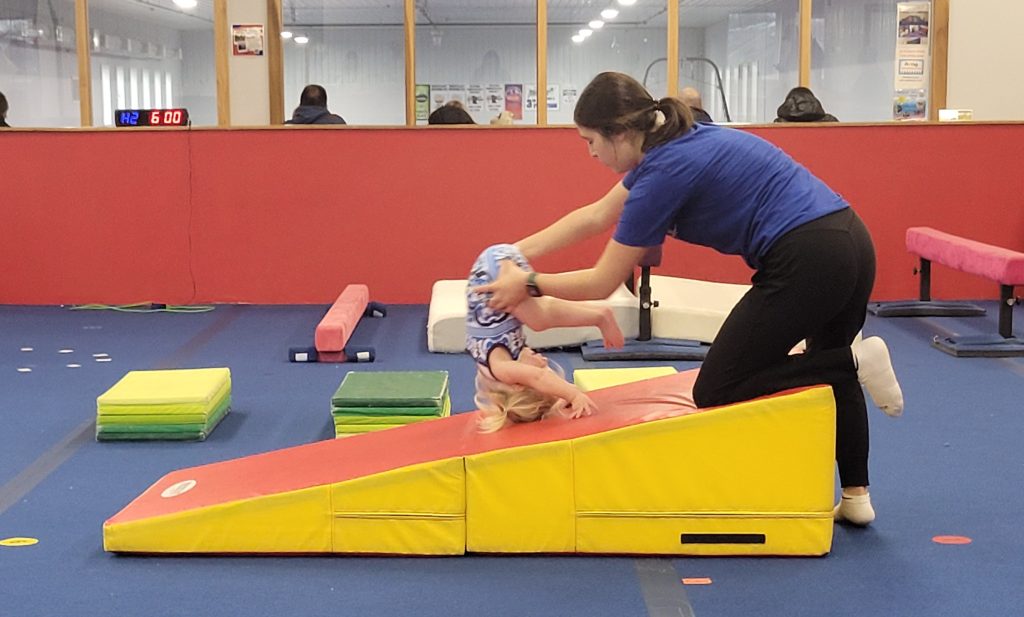 A child learning to tumble with assistance