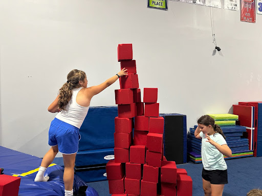 Two girls building a block tower at Camp ROGA summer camp.