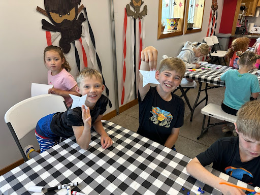Campers showing off paper ninja stars at Camp ROGA summer camp.
