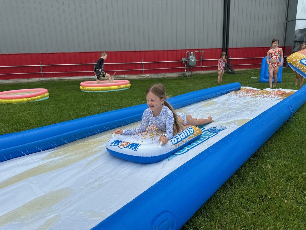 A girl on a slip and slide at Camp ROGA