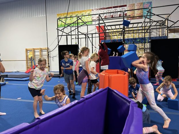 Kids at Camp ROGA jumping in the indoor gymnastics play area