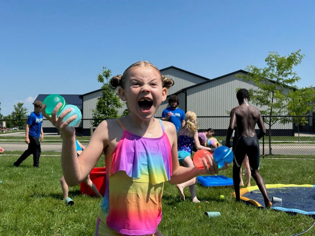 Camper holding water balloons at Camp ROGA summer camp.