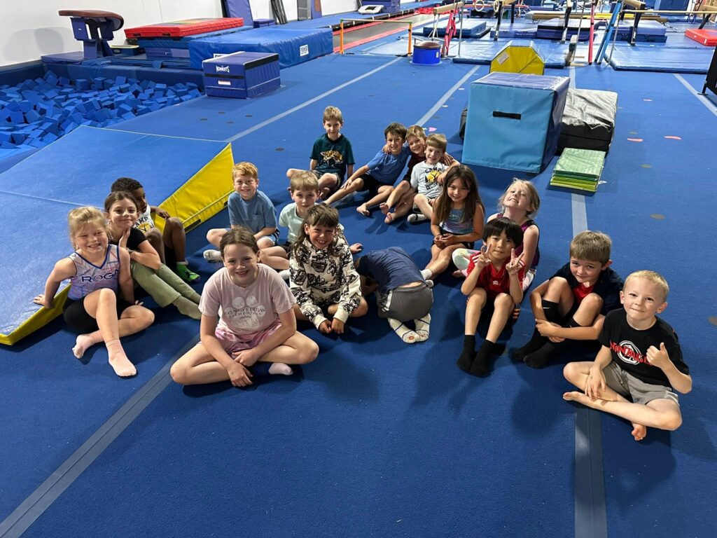 Camp ROGA ninja campers gather together on the gymnastics floor after a day of training and adventures.