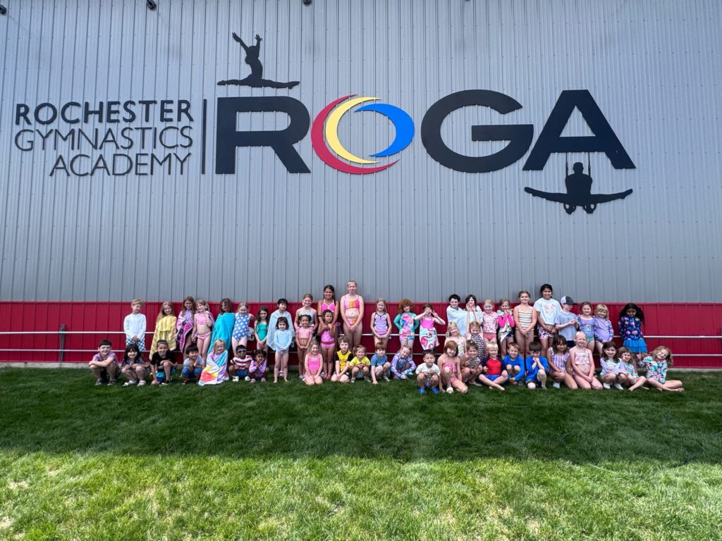 Camp ROGA campers gather outside Rochester Gymnastics Academy for a group photo during Beach Bash week at summer camp.