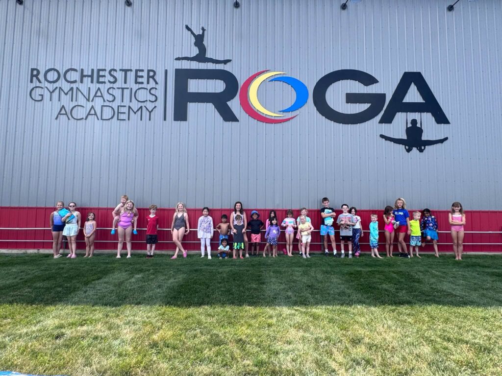 Camp ROGA campers and coaches pose together outside Rochester Gymnastics Academy during Harry Potter Week summer camp.