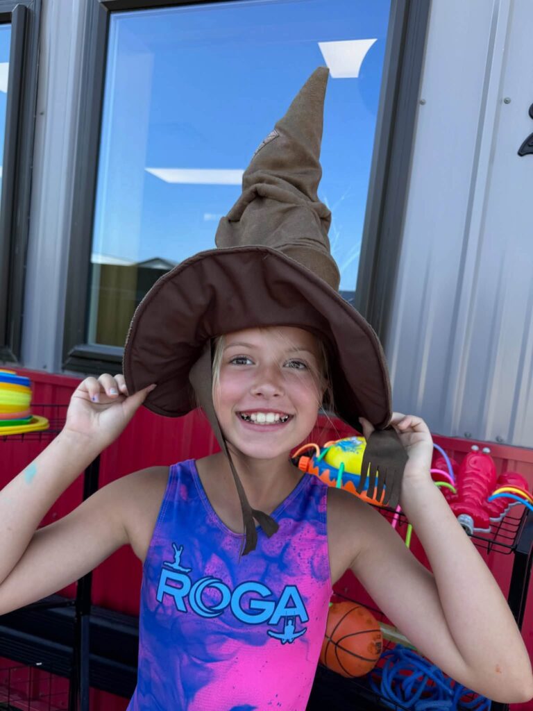 Smiling Camp ROGA camper wearing a Hogwarts sorting hat during Harry Potter Week at summer camp.